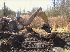 Backhoe digging at secondary beaver dam